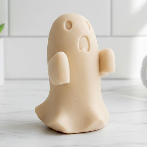 Ghost-shaped soap on a bathroom counter with towels and a plant in the background