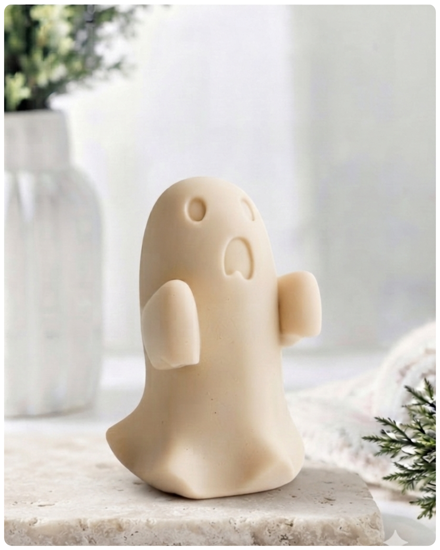 Ghost-shaped soap on a bathroom counter with towels and a plant in the background