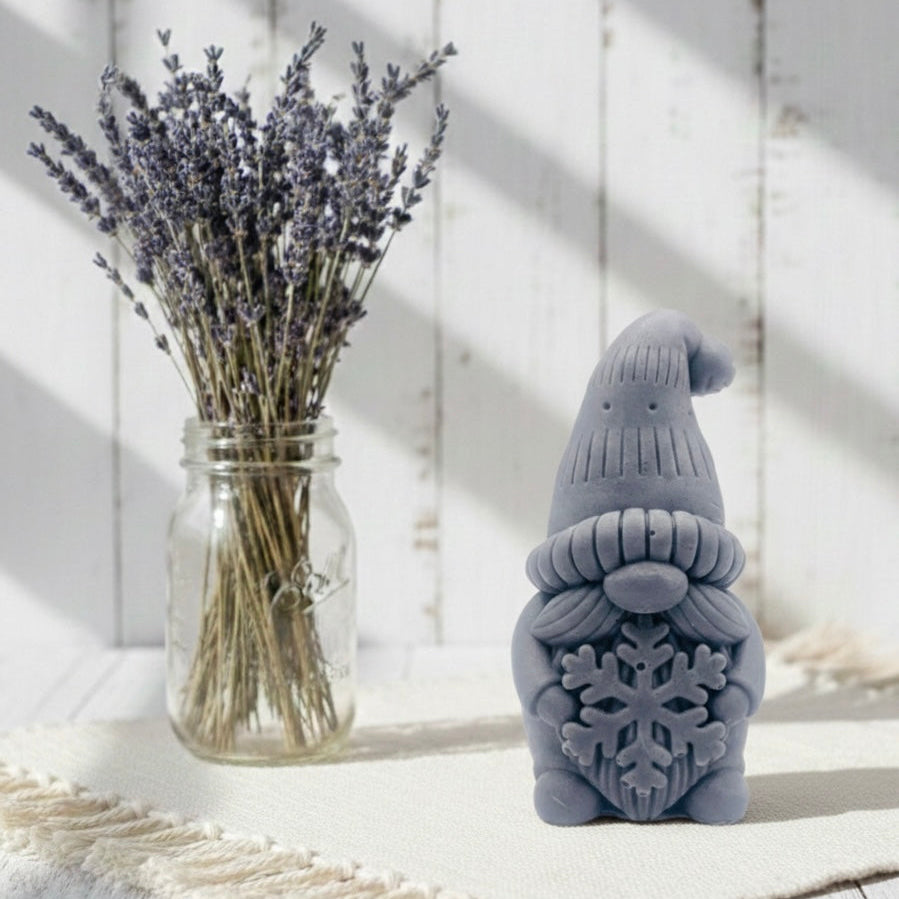 Handmade vegan soaps featuring a christmas gnome holding a snowflake in beautiful eco friendly packaging crafted with natural French clays, activated charcoal and essential oils. 