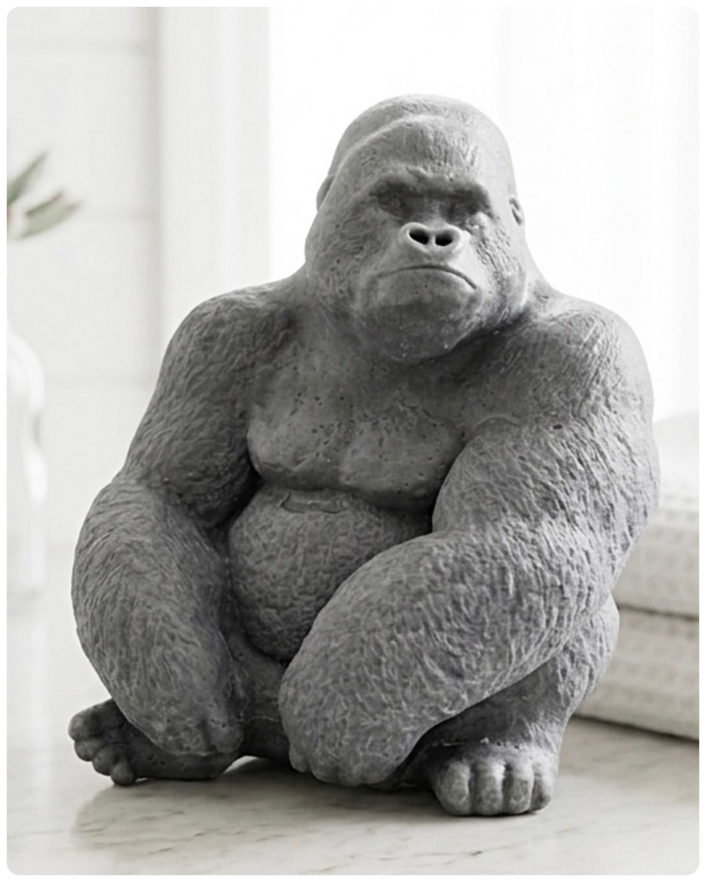 Gray large gorilla soap statue on a wooden surface with a blurred background