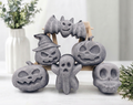 Complete set of six chunky activated charcoal Halloween soaps including bats, ghosts, skulls, and carved pumpkins arranged on a wooden easel against a bright backdrop.