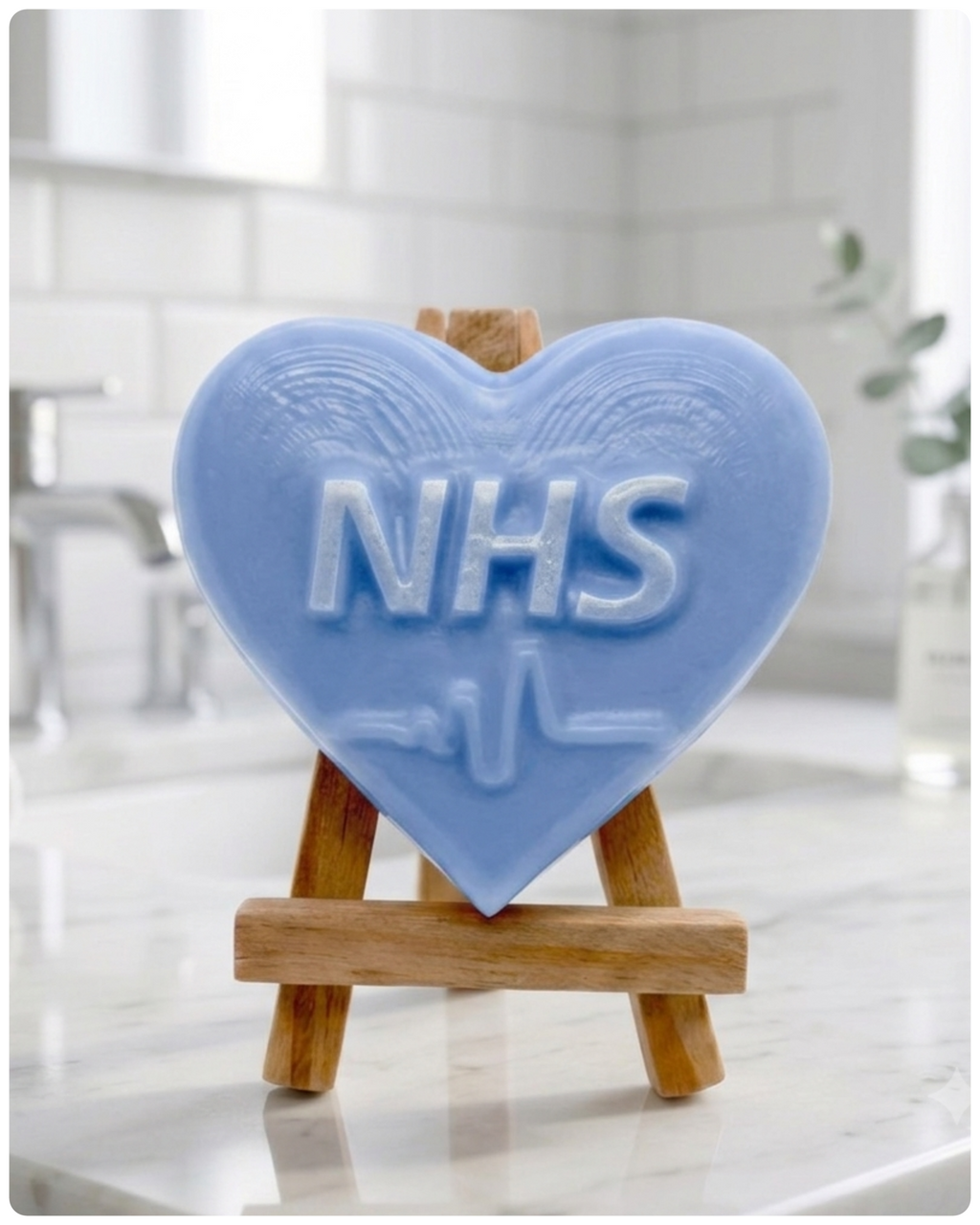 handmade vegan soap in a heart shape featuring an "NHS" relief and a heartbeat pulse line, displayed on a small wooden easel