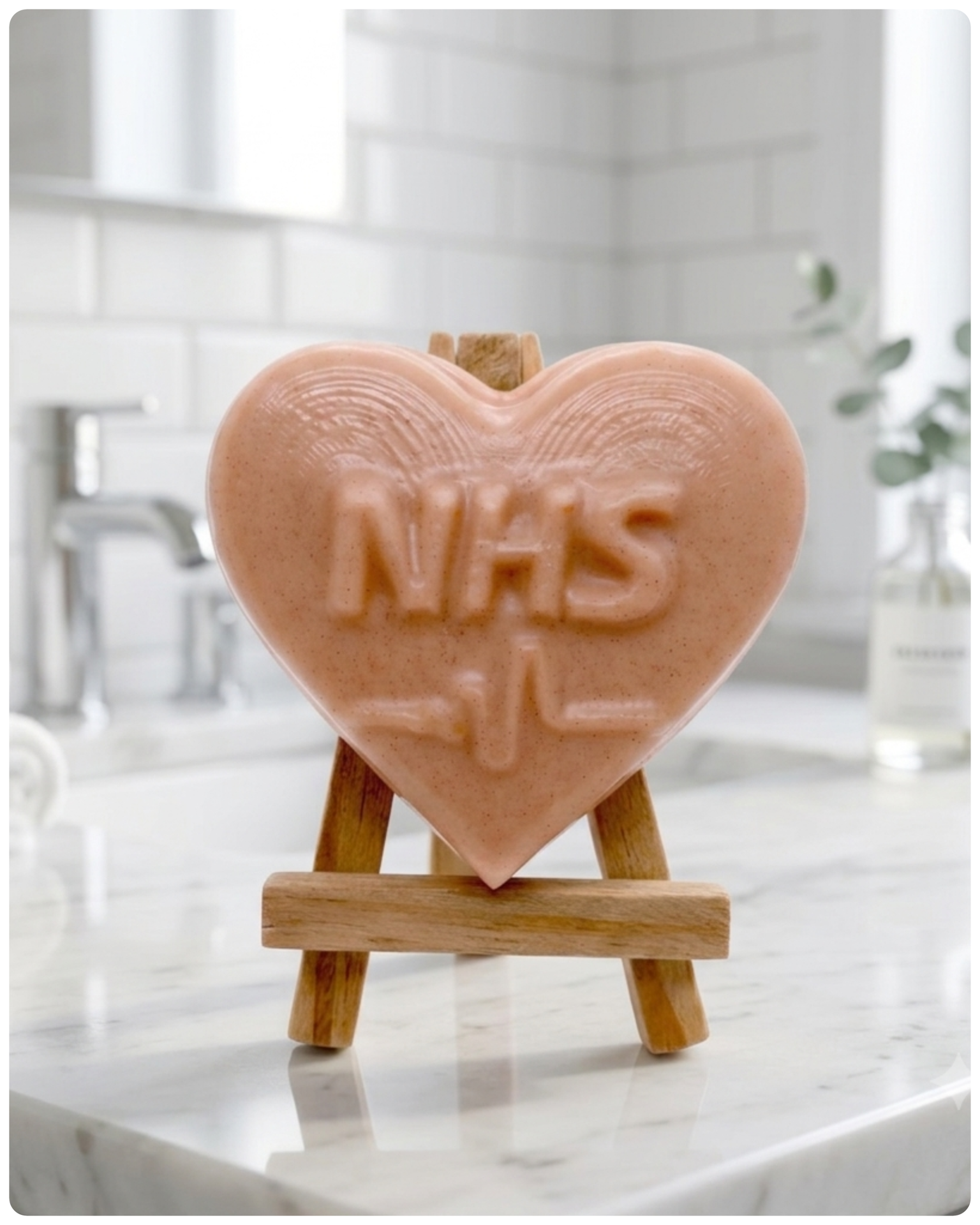handmade vegan soap in a heart shape featuring an "NHS" relief and a heartbeat pulse line, displayed on a small wooden easel