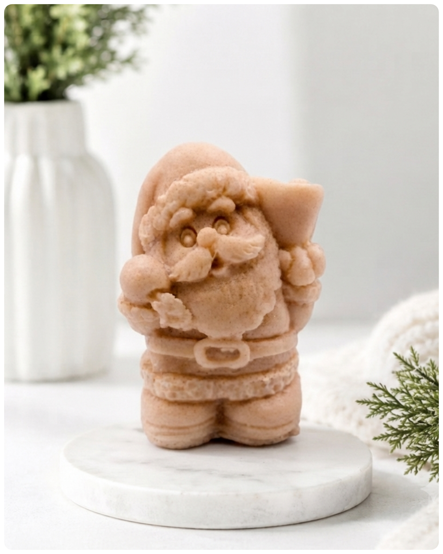 A highly detailed 3D handmade vegan soap featuring a Father Christmas carrying a large sack of gifts over his shoulder and holding a bell, featuring an intricate curly beard and fur-trimmed suit, set against a festive holiday background.