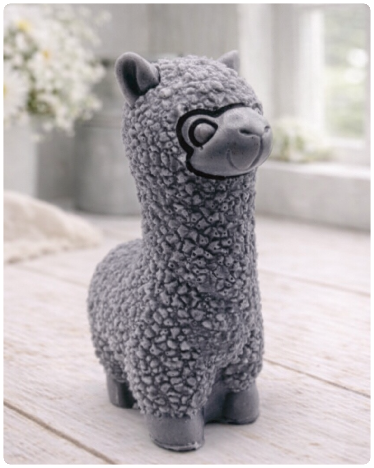 handmade vegan soap in the shape of a realistic standing alpaca sculpture, featuring detailed curly wool texture and a smiling face, displayed on a rustic white wooden surface in a bright farmhouse decor setting.
