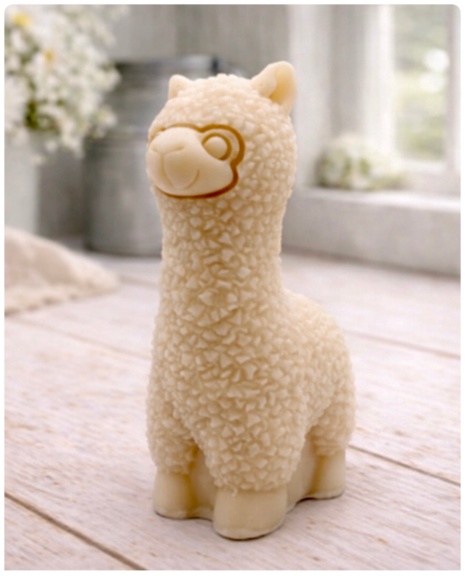 handmade vegan soap in the shape of a realistic standing alpaca sculpture, featuring detailed curly wool texture and a smiling face, displayed on a rustic white wooden surface in a bright farmhouse decor setting.