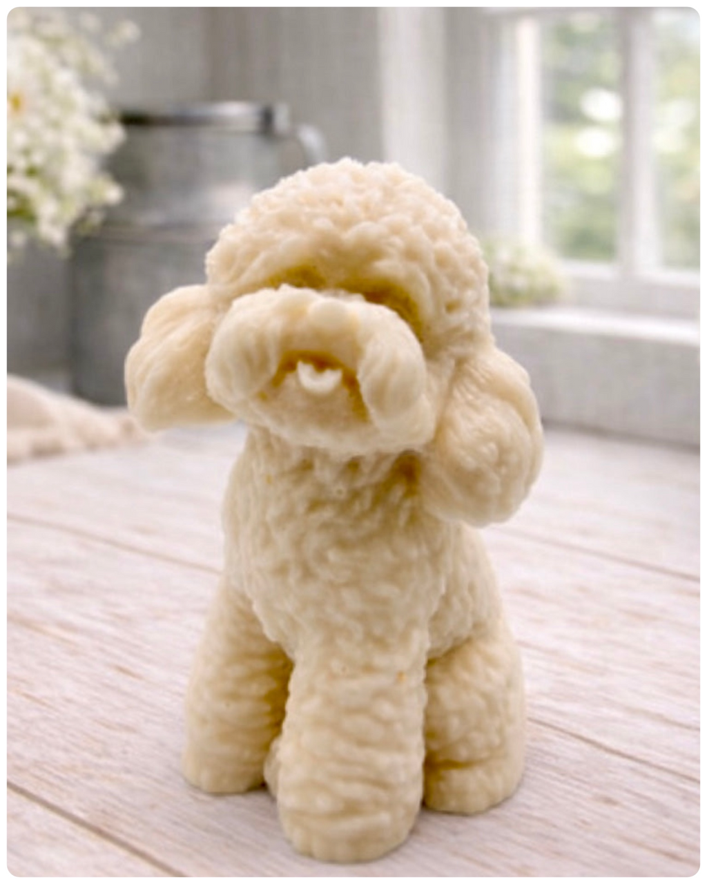 handmade vegan soap in the shape of a realistic sitting cockapoo or poodle sculpture, featuring detailed curly fur texture and a classic poodle groom, displayed on a rustic white wooden surface in a bright farmhouse decor setting.
