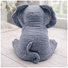 Load image into Gallery viewer, A crisp product photograph of a detailed, grey artisan bar of soap intricately moulded into the shape of a sitting baby elephant. The elephant is depicted holding its trunk with its front legs crossed in a "hear no evil" or hugging pose, showcasing realistic skin textures, expressive eyes, and large ears.
