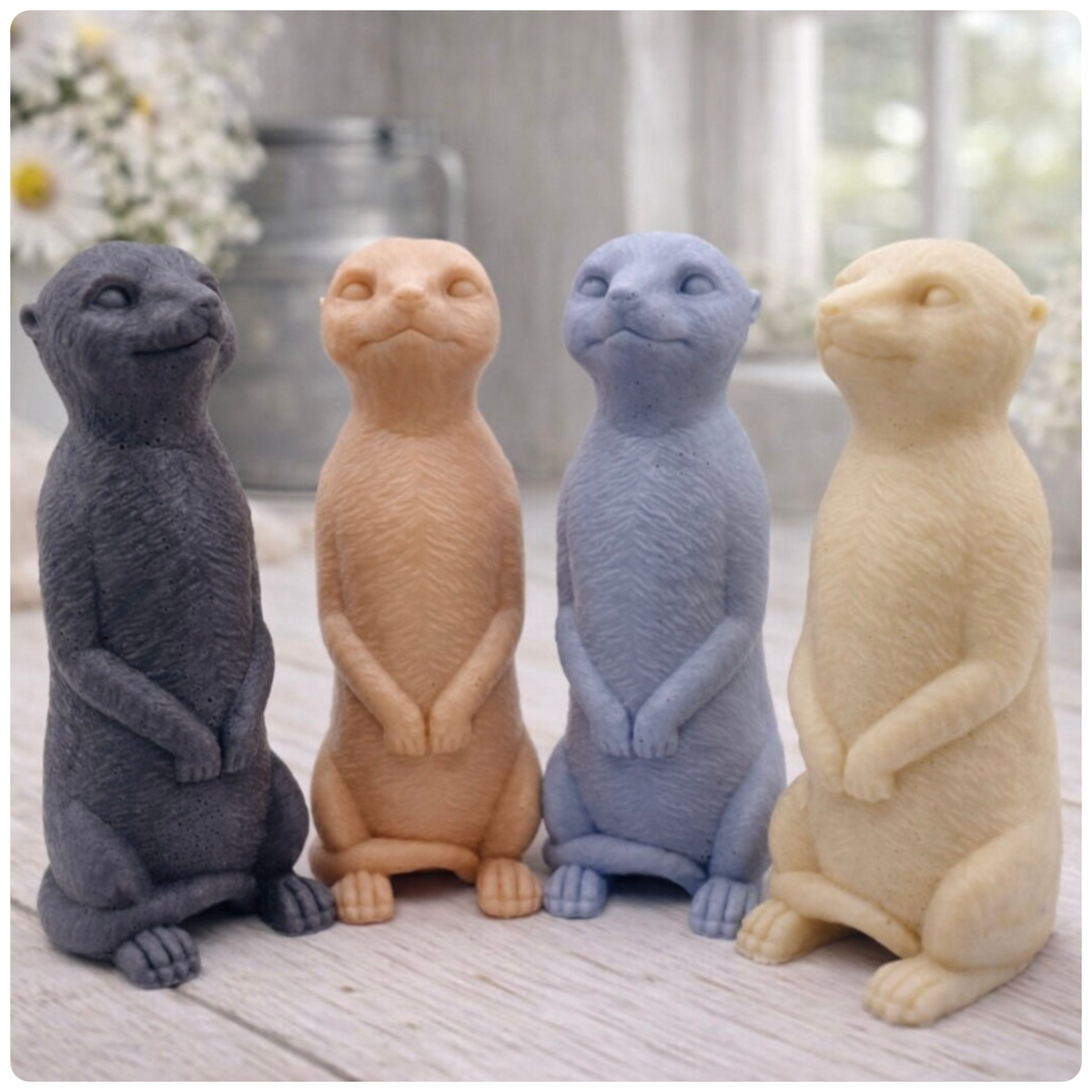 A highly detailed handmade vegan soap, sculpted in the shape of a realistic meerkat standing upright in its iconic sentinel pose, featuring textured fur and a curious facial expression, displayed on a light wooden surface.