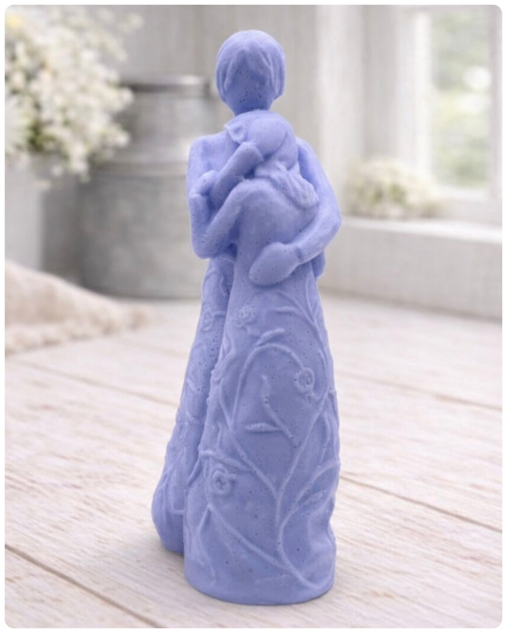 handmade vegan soap, sculpted as a mother and daughter in a tender standing embrace, featuring an intricate embossed floral and vine pattern on their dresses.