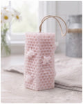 A tall, rectangular handmade vegan soap with a detailed honeycomb texture on all sides and small embossed bees, featuring a natural twine hanging rope, displayed upright on a light wooden surface.