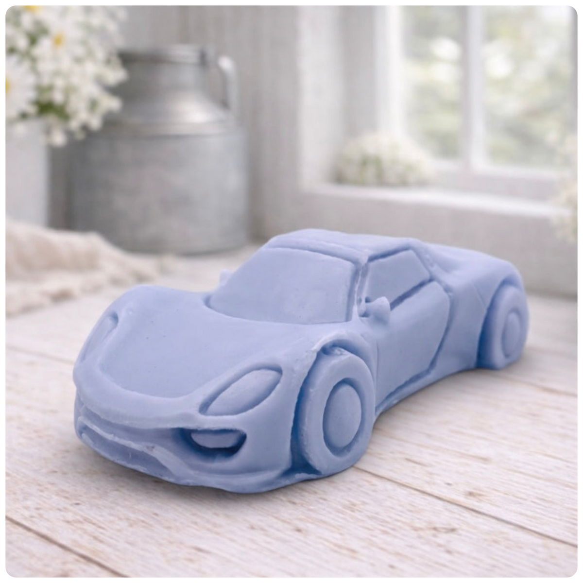 handmade vegan soap in the shape of a sleek supercar sculpture, featuring aerodynamic curves and detailed wheels, displayed on a rustic white wooden surface in a bright farmhouse decor setting.