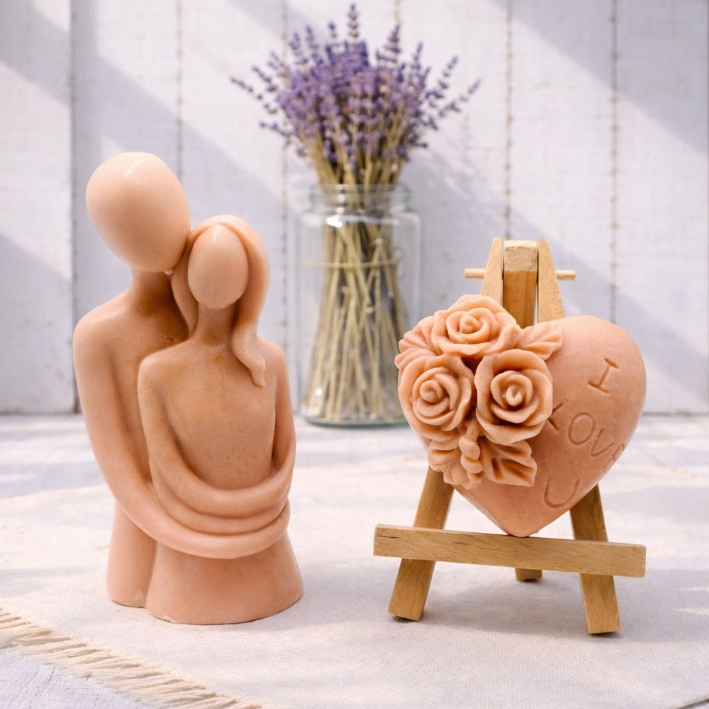 This gift set features a stunning soap sculpture of a man gently embracing a woman alongside a charming rose-adorned heart soap, stamped with the heartfelt message "I LOVE U".