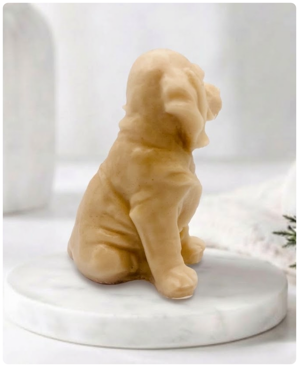A yellow Golden Retriever soap sitting on a white marble display stand with a soft bathroom background.