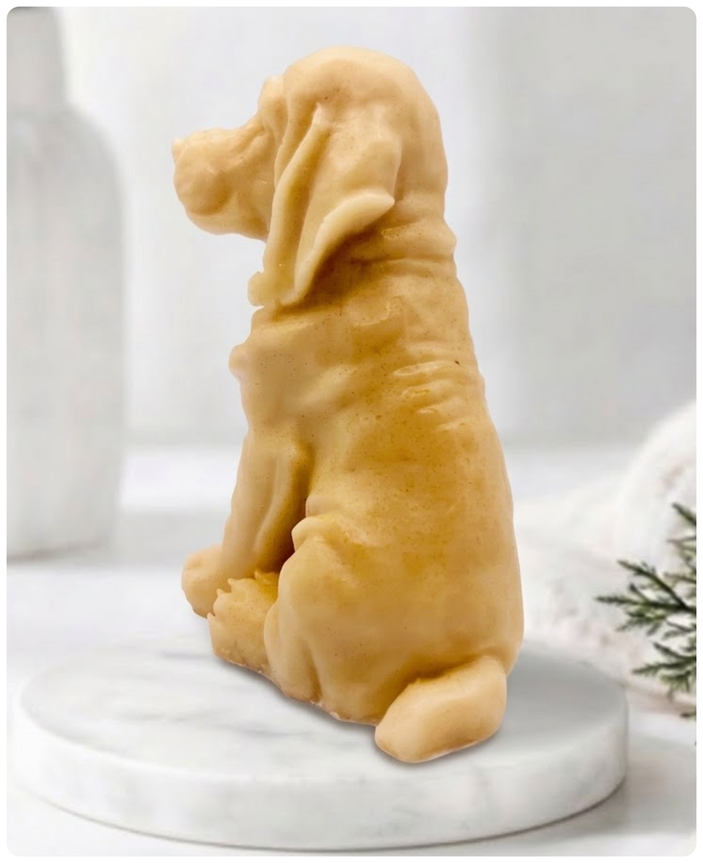 A yellow Golden Retriever soap sitting on a white marble display stand with a soft bathroom background.