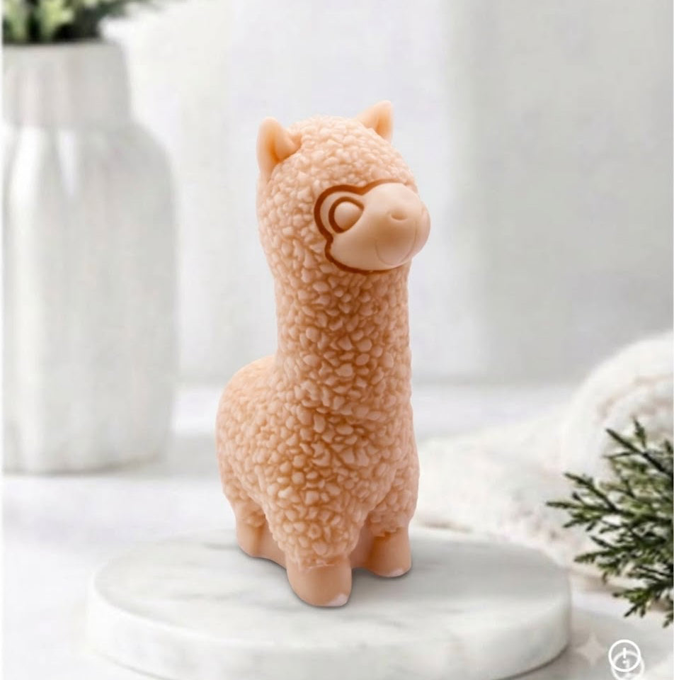 handmade vegan soap in the shape of a realistic standing alpaca sculpture, featuring detailed curly wool texture and a smiling face, displayed on a rustic white wooden surface in a bright farmhouse decor setting.