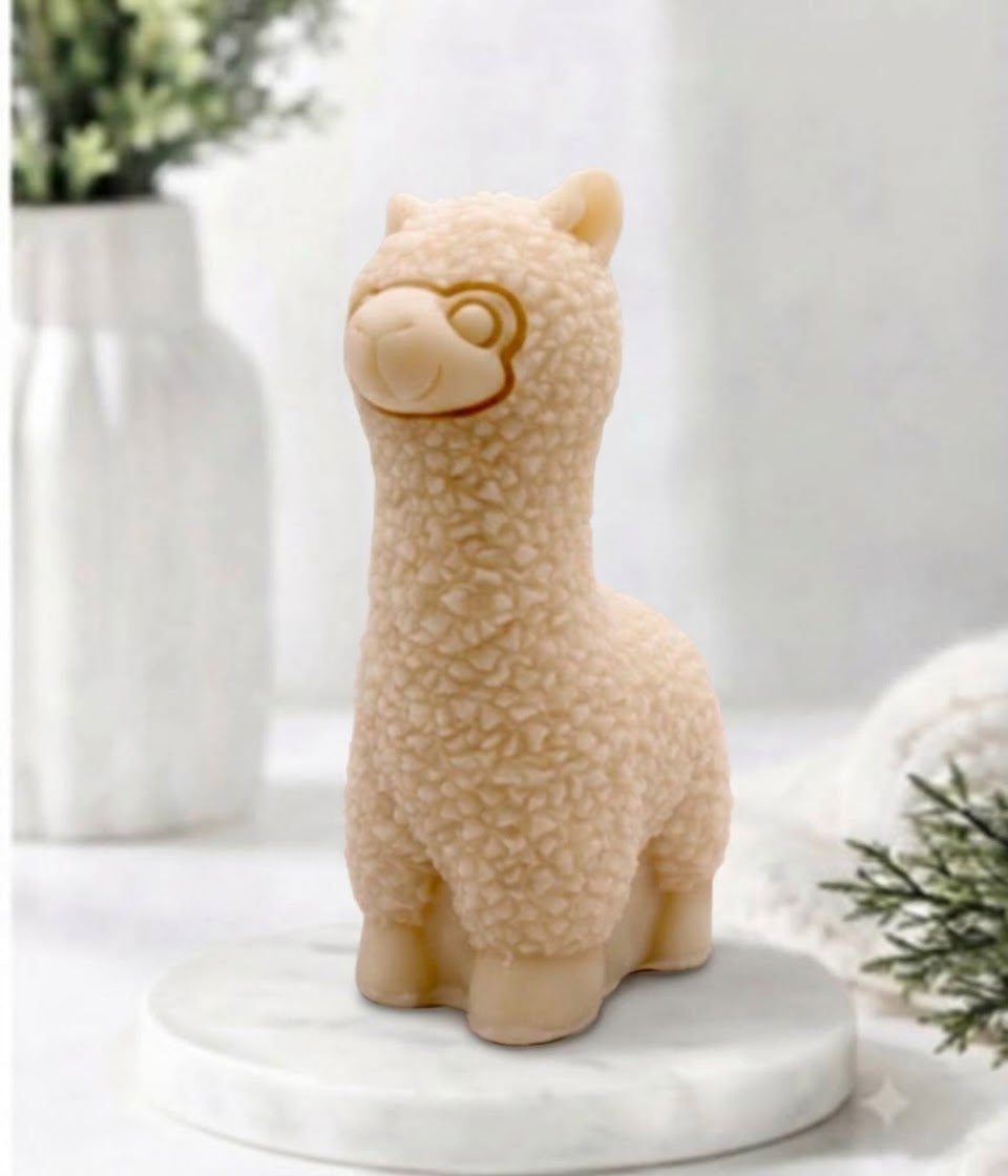 handmade vegan soap in the shape of a realistic standing alpaca sculpture, featuring detailed curly wool texture and a smiling face, displayed on a rustic white wooden surface in a bright farmhouse decor setting.