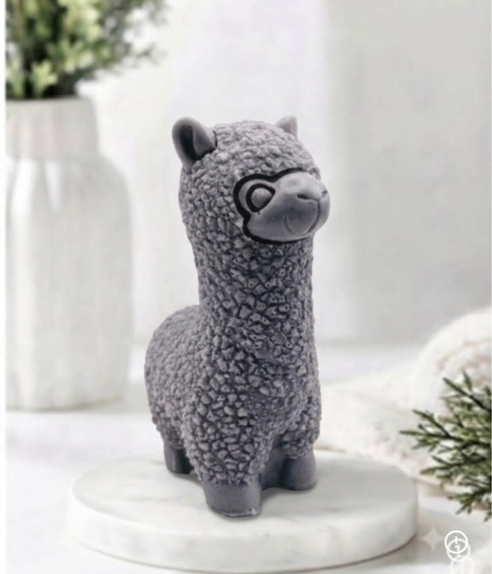 handmade vegan soap in the shape of a realistic standing alpaca sculpture, featuring detailed curly wool texture and a smiling face, displayed on a rustic white wooden surface in a bright farmhouse decor setting.