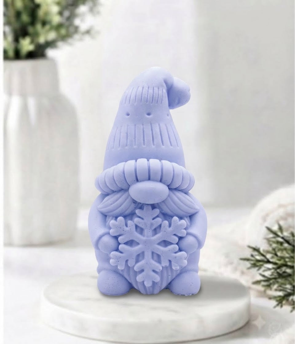 handmade blue vegan soap in the shape of a winter gnome sculpture holding a large snowflake, featuring a tall textured hat and a bushy moustache 