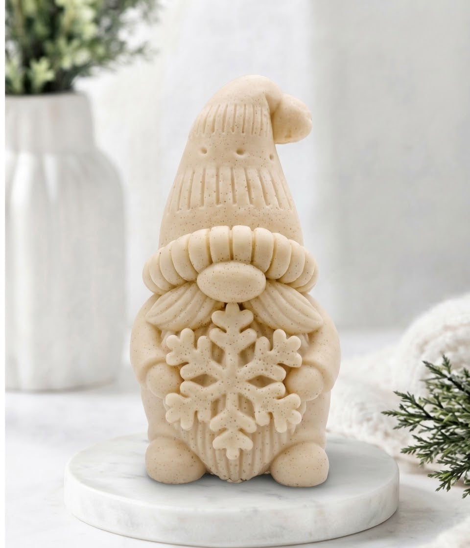 handmade yellow vegan soap in the shape of a winter gnome sculpture holding a large snowflake, featuring a tall textured hat and a bushy moustache 