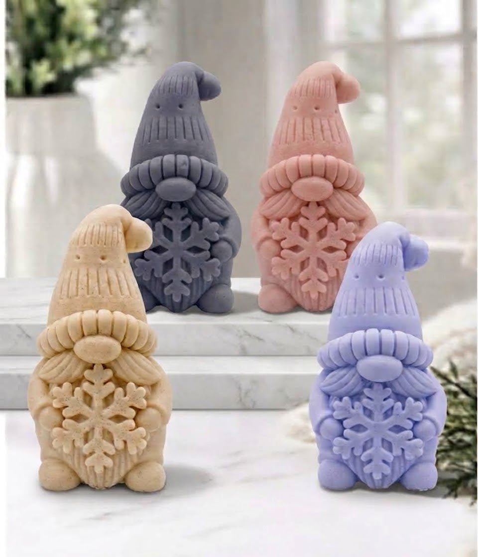 Four handmade vegan soaps in the shape of a winter gnome sculpture holding a large snowflake, featuring a tall textured hat and a bushy moustache