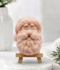 handmade pink vegan soap sculpted in the shape of Father Christmas's head, featuring a detailed curly beard, a jolly moustache, and a classic Santa hat.