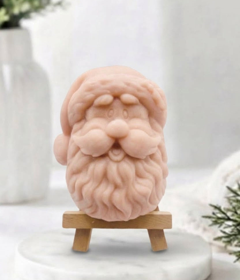 handmade pink vegan soap sculpted in the shape of Father Christmas's head, featuring a detailed curly beard, a jolly moustache, and a classic Santa hat.