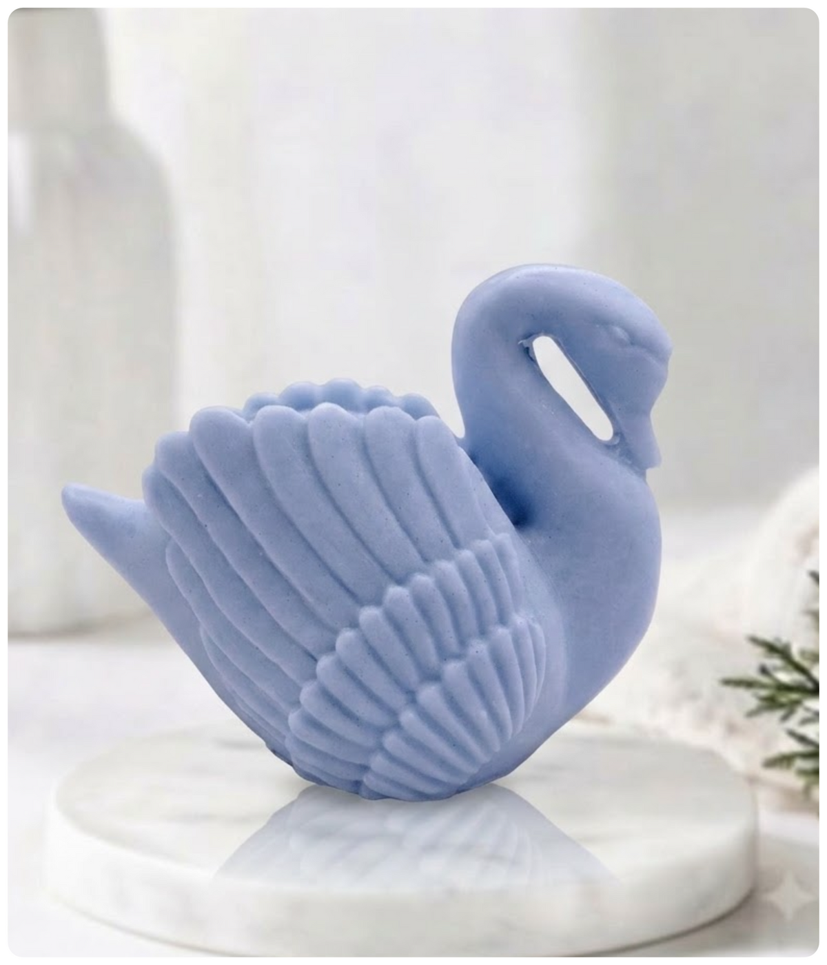 A side profile of a blue swan soap bar resting on a marble pedestal.