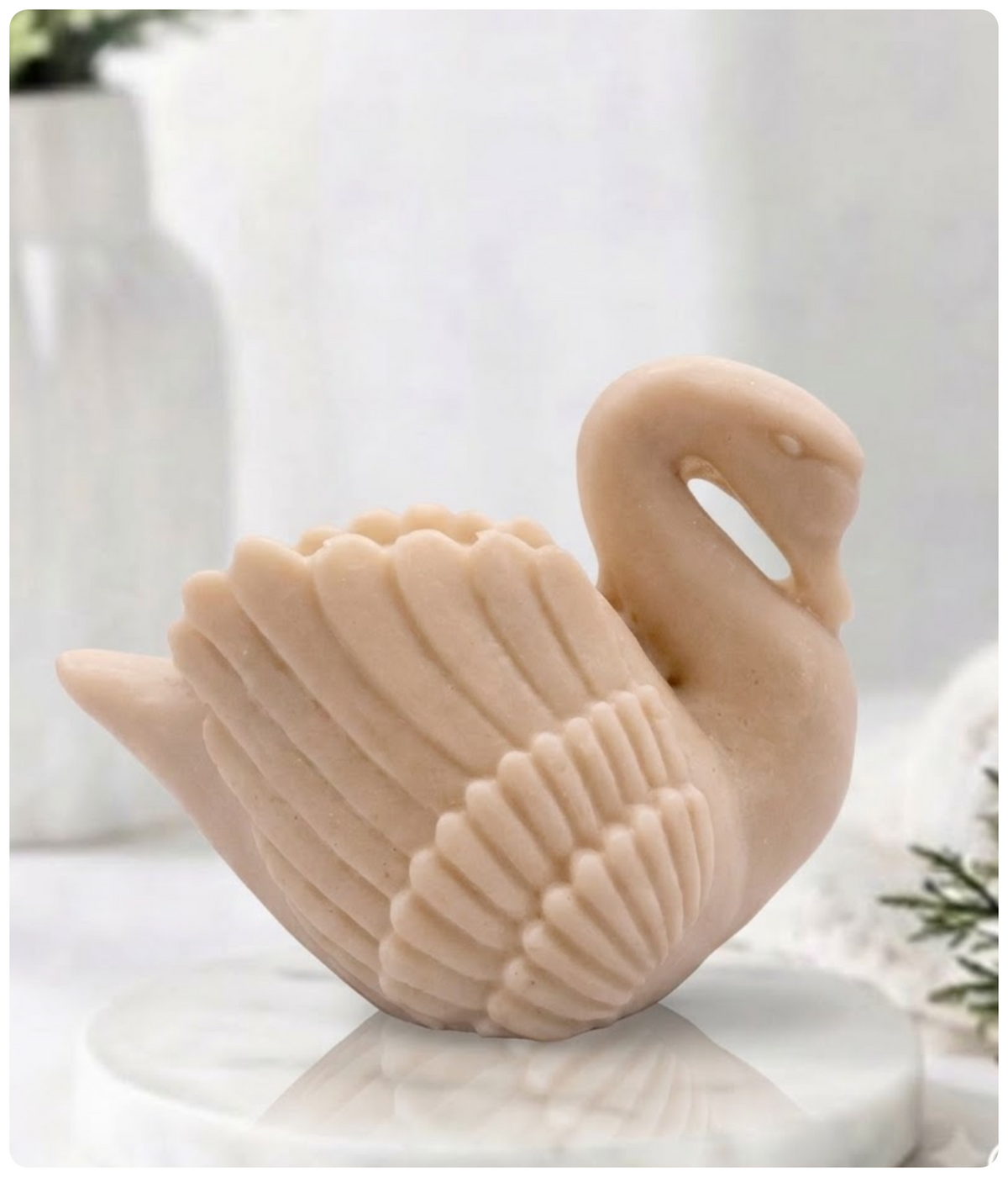 A side profile of a yellow swan soap bar resting on a marble pedestal.