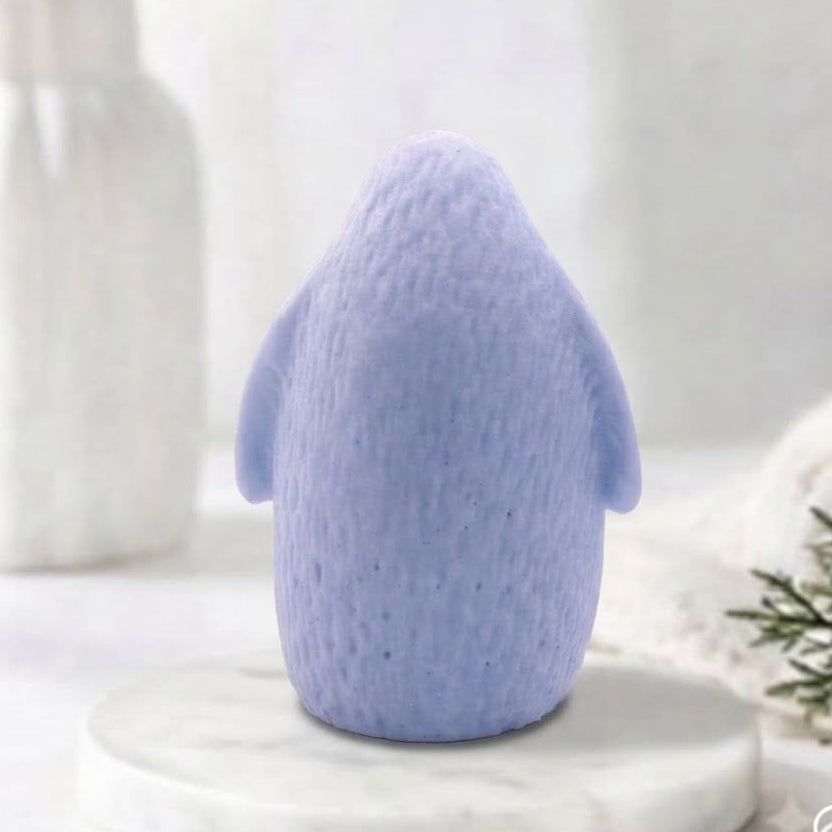 Rear view of a handmade light blue indigo penguin-shaped soap showing textured feather details.