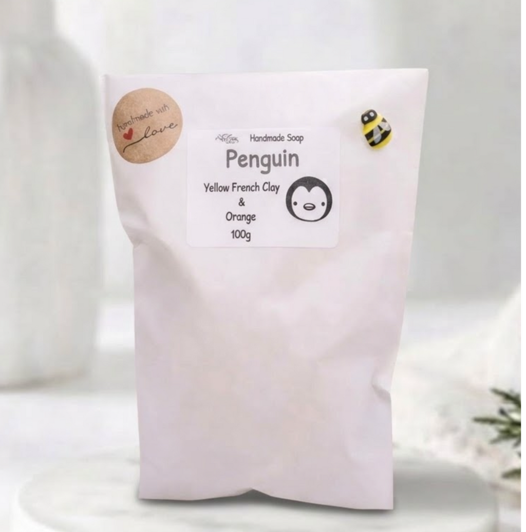 White paper eco-friendly soap packaging bag labeled "Penguin Handmade Soap" with a cute bumblebee accent craft pin.