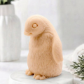 Handmade soft pink clay penguin-shaped soap sitting upright on a white marble display plate.