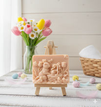 Load image into Gallery viewer, Intricate handmade soap scene from Soap Simple Creations featuring an Easter bunny, chicks, and tulips, displayed on a wooden easel with spring flowers. Vegan and cruelty free soap. 
