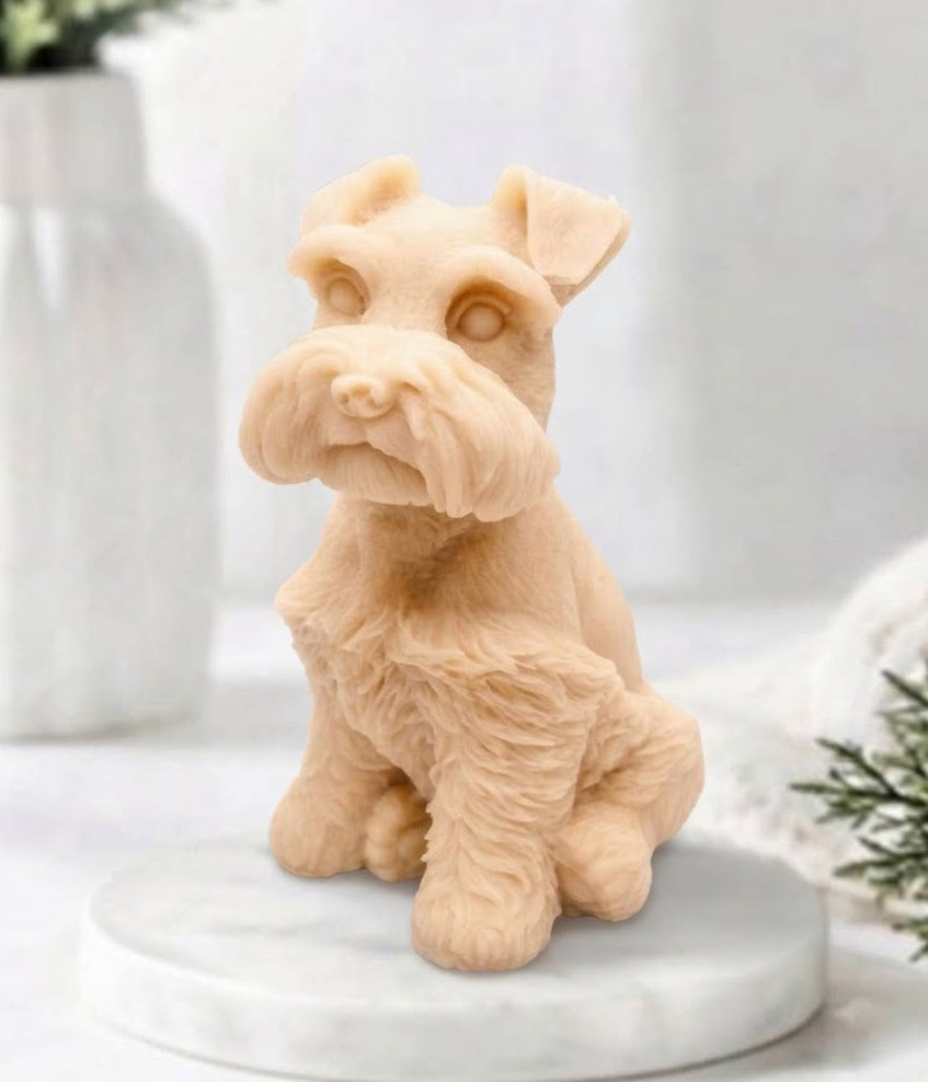 A soft pink schnauzer dog vegan soap gift with detailed fur texture, sitting on a round white marble base against a softly blurred light background with decorative plants.