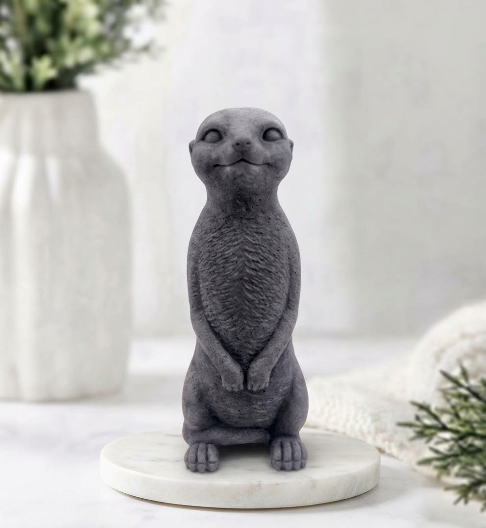 Handmade vegan meerkat soap made with activated charcoal, shaped like a standing meerkat facing forward on a marble tray display.