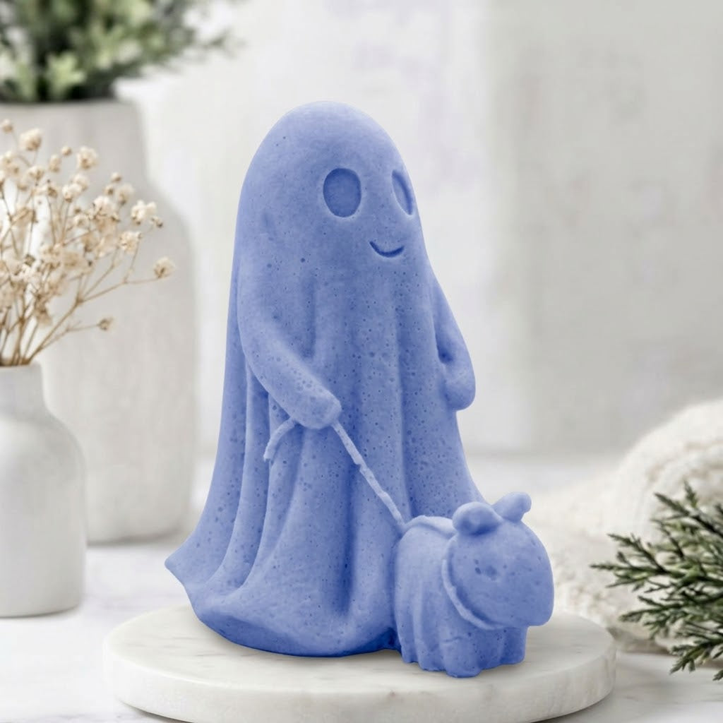 A soft blue decorative vegan soap figure of a ghost with a dog on a leash in a bright room with flowers.