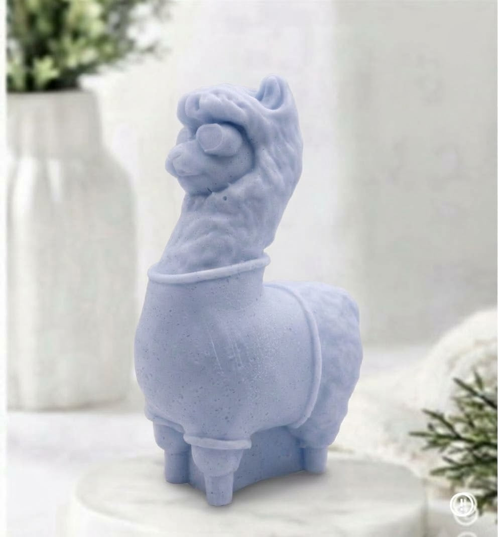 A soft blue coloured decorative llama / alpaca shaped vegan soap on a white surface.