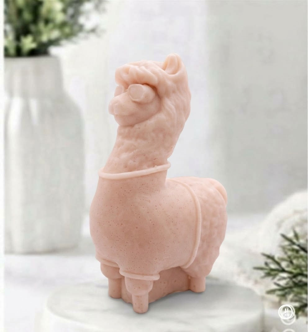A soft pink coloured decorative llama / alpaca shaped vegan soap on a white surface.