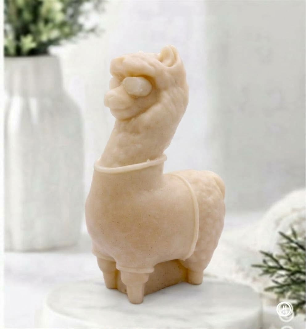 A soft yellow coloured decorative llama / alpaca shaped vegan soap on a white surface.