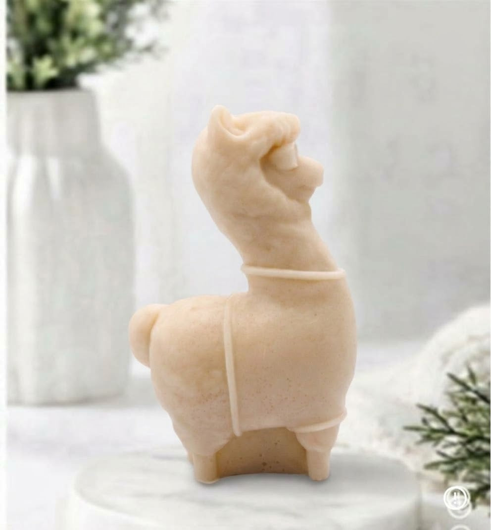 A side view of a soft yellow coloured decorative llama / alpaca shaped vegan soap on a white surface.