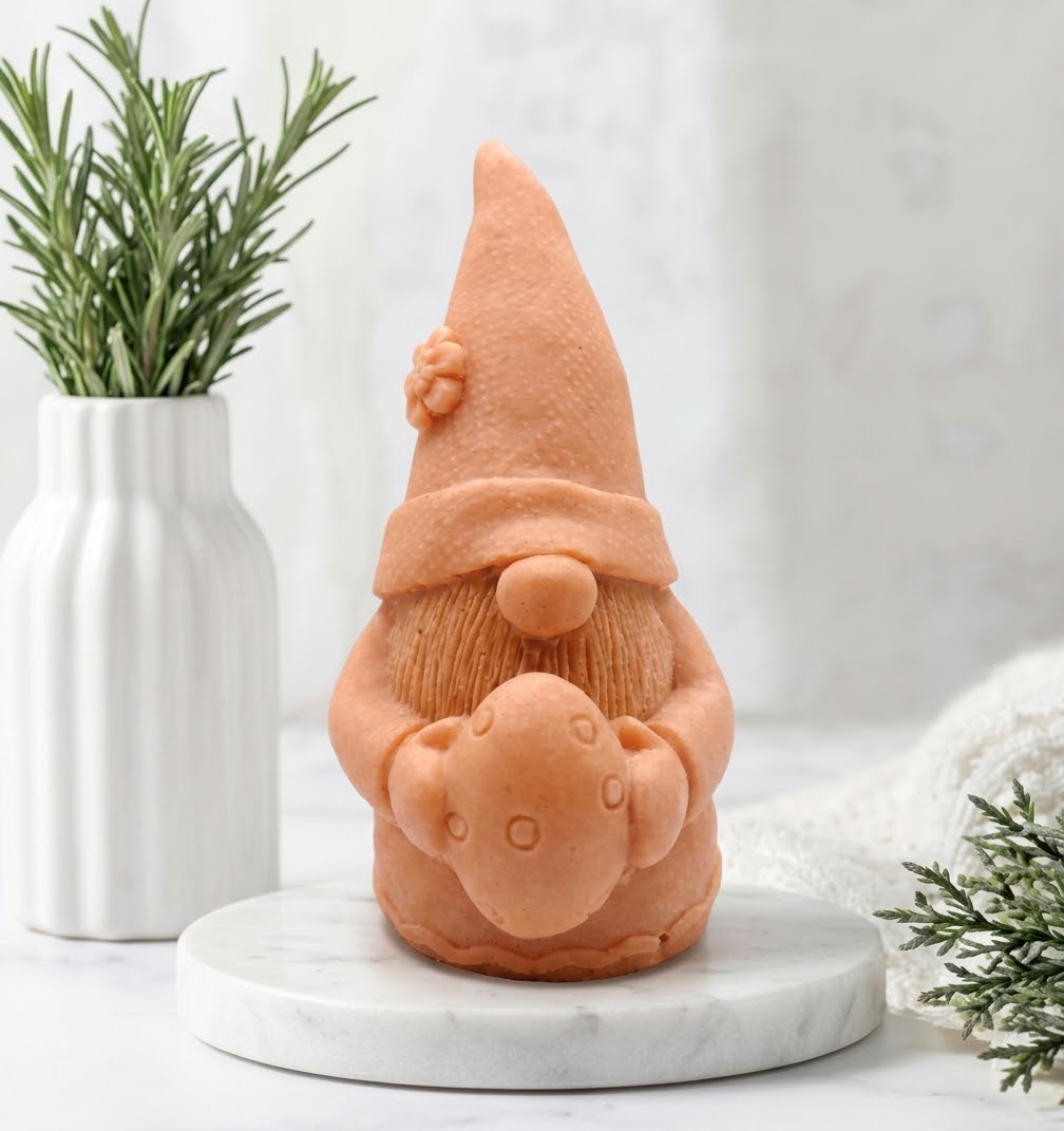 An terracotta-coloured gnome soap holding an Easter egg, displayed on a round white marble tray.