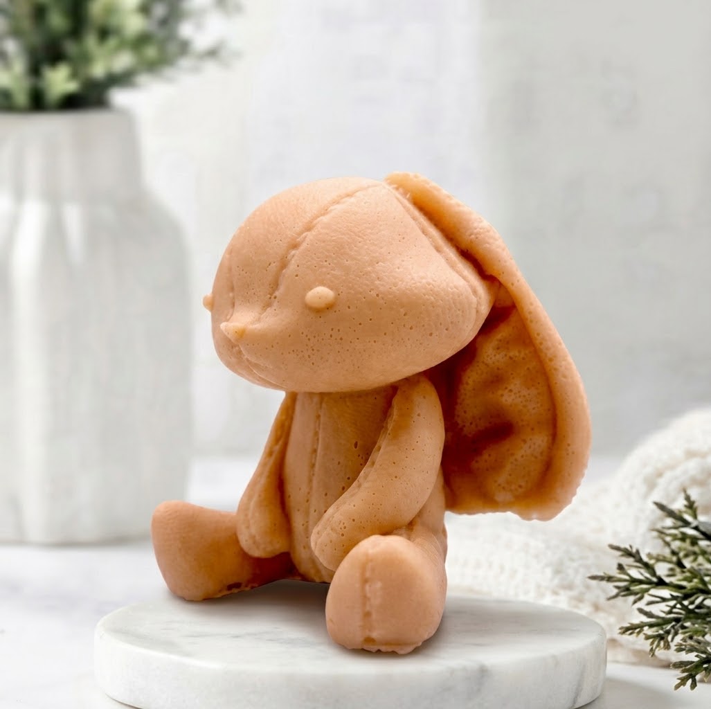 A side view of a handmade terracotta coloured vegan soap featuring an adorable rabbit with big floppy ears and stitching detail