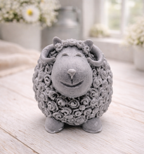 Load image into Gallery viewer, A highly detailed handmade vegan soap sculpted in the shape of a sturdy ram with a thick coat of tight, curly wool and large, elegant curved horns, displayed on a light wooden surface in a bright farmhouse setting.

