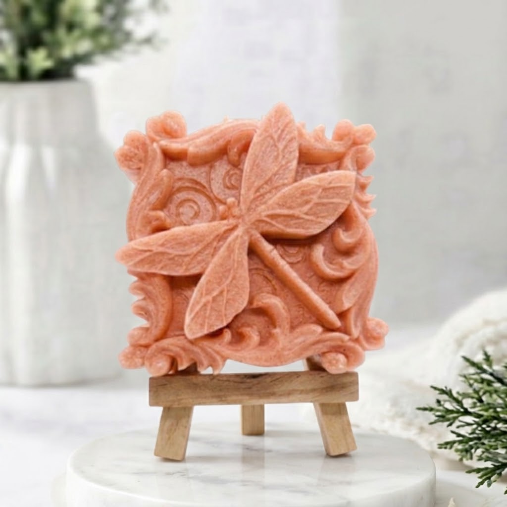 Coral pink carved artisan vegan soap featuring a central dragonfly and decorative border.
