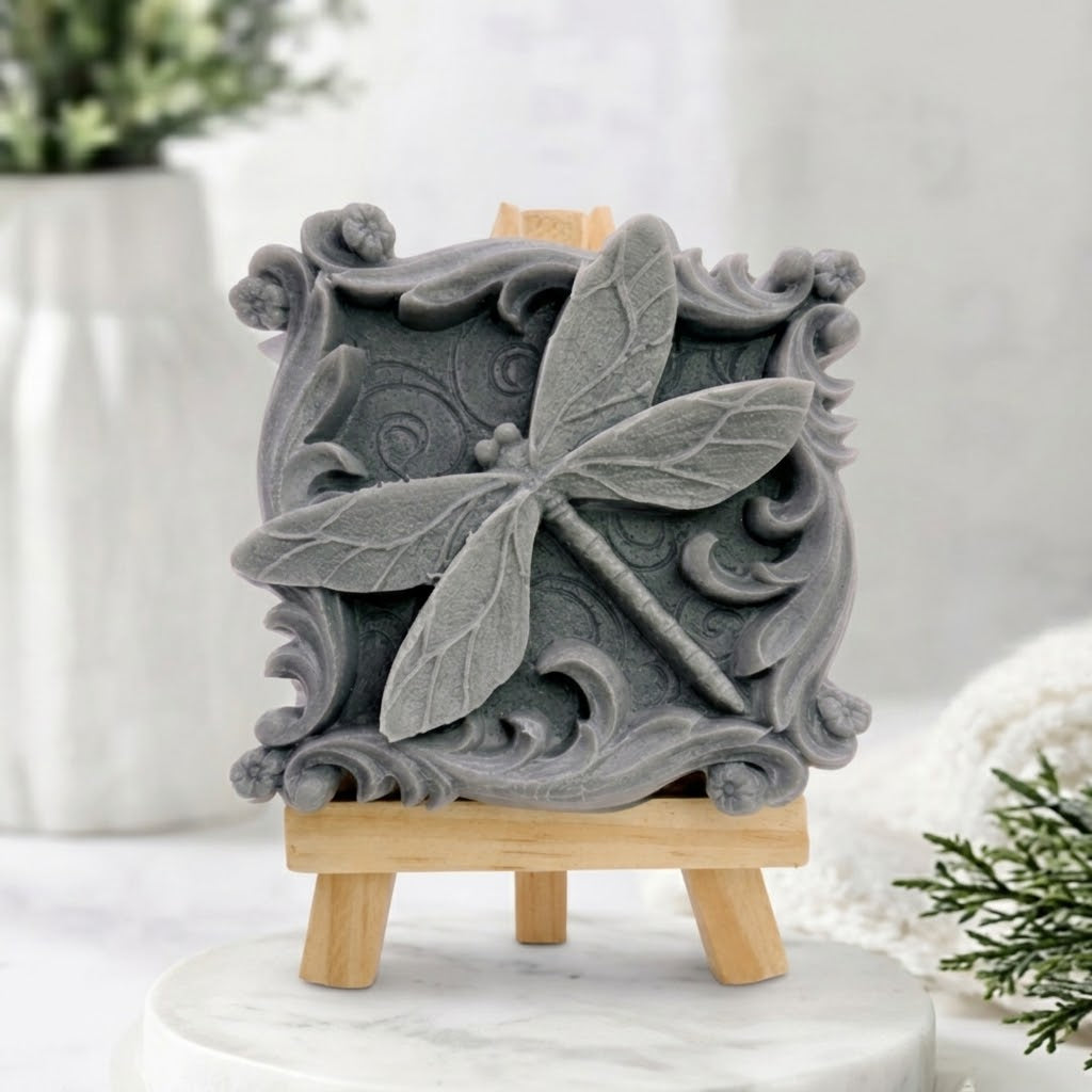Grey charcoal sculpted artisan vegan soap with detailed dragonfly and scrollwork carving.