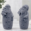 Handmade charcoal grey Santa Christmas soap featuring a textured robe, stars, holding a Christmas tree and lantern.