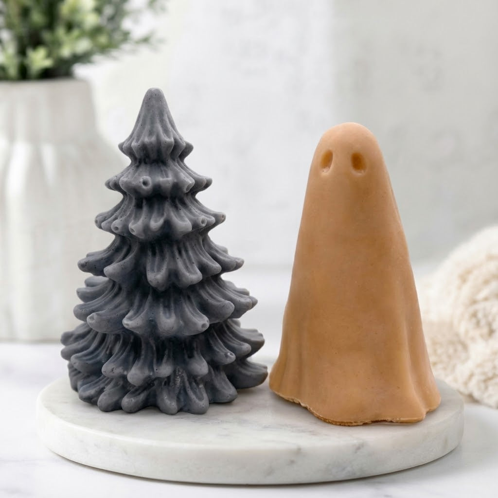 Handmade vegan soap gift set with a grey Christmas tree soap and a terracotta coloured ghost soap arranged on a white marble surface.
