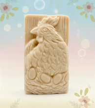 Load image into Gallery viewer, Handmade vegan soaps featuring a chicken sat on her nest of eggs,  in beautiful eco friendly packaging. crafted with natural French clays, activated charcoal and essential oils. a eco-friendly, zero waste gift that’s cruelty-free, skin-nourishing, the perfect gift for easter and animal lovers. small business UK
