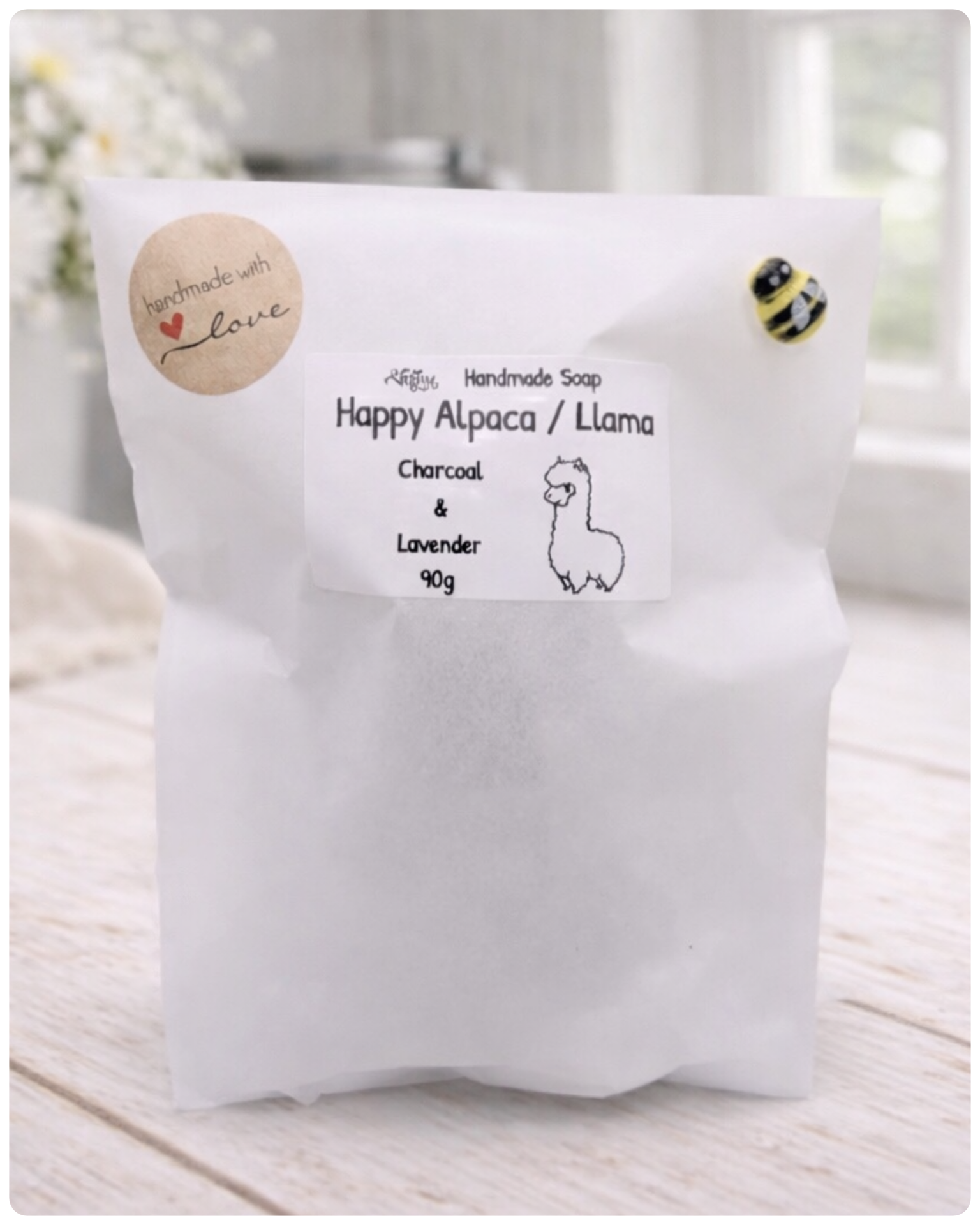 White soap bag with a label for Happy Alpaca/Llama soap on a light wooden surface.