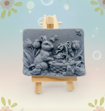 Load image into Gallery viewer, Handmade vegan soaps featuring the easter bunny with a basket full of chicks. , in beautiful eco friendly packaging. crafted with natural French clays, activated charcoal and essential oils. a eco-friendly, zero waste gift that’s cruelty-free, skin-nourishing, the perfect gift for easter and animal lovers. small business UK
